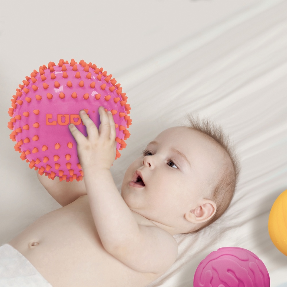 Baby holding a ball LUDI sensoriniai kamuoliukai, rožinė ir geltona, 3 vnt.